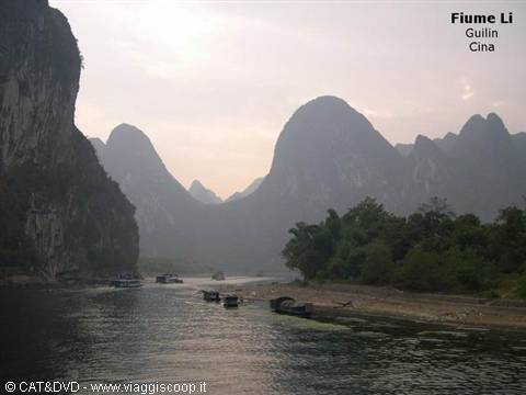 Boat drifting on the calm Li River in Guilin among misty limestone peaks