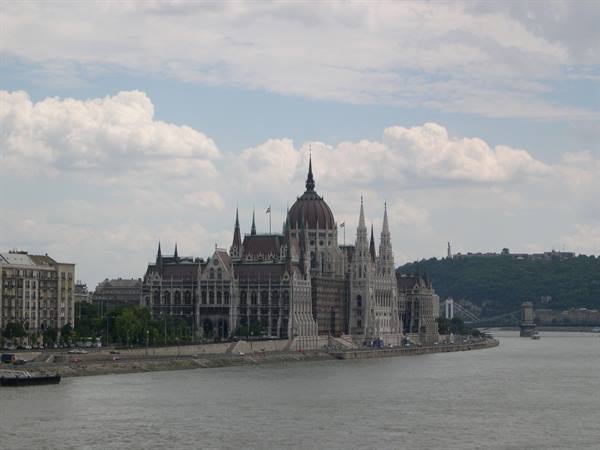 Budapest Parliament building on the Danube riverbank under white clouds