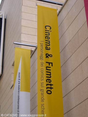 Yellow banners reading Cinema & Fumetto hang on a modern art museum facade