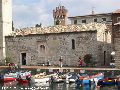 Stone church and medieval tower above moored boats at Lazise
