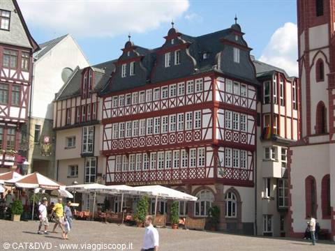 Rebuilt half-timbered houses on Frankfurt's Römerberg square, pedestrians under white umbrellas