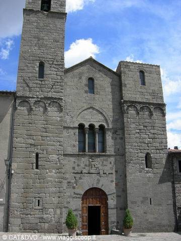 Medieval stone church with bell tower and wooden arched portal