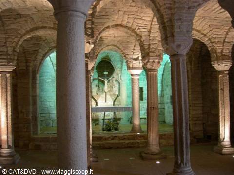 Romanesque columns in San Miniato al Monte crypt, green light on the crucifix