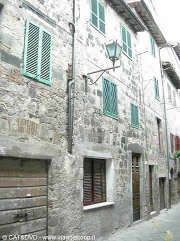 Stone houses with green shutters and lantern along narrow alley