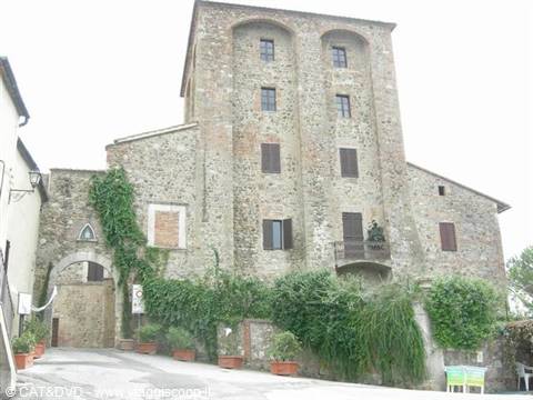 old stone village with medieval tower, ivy-covered walls, flower pots on steps