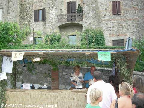 Straw market stall with vendors in front of old stone village