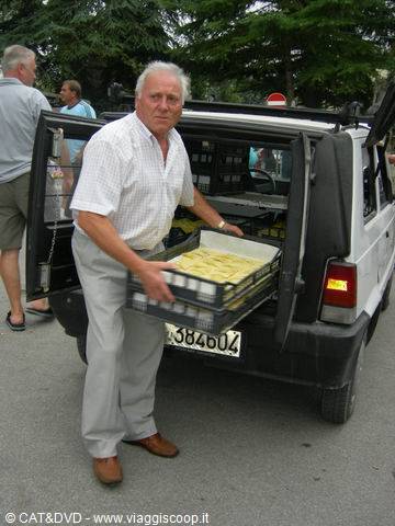 Man unloads trays of pastries from a white van on the street