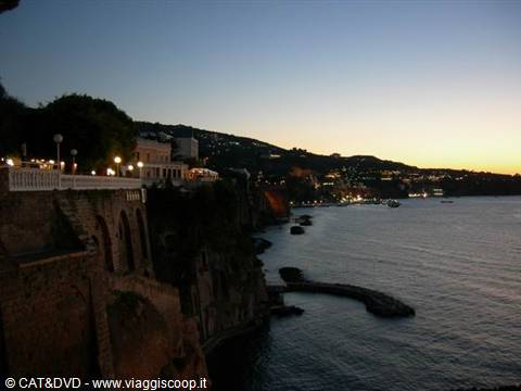 Sorrento: lit terrace above tuff cliffs at dusk