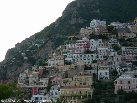 Positano's colorful houses stacked on the rocky cliffside beneath a gray sky