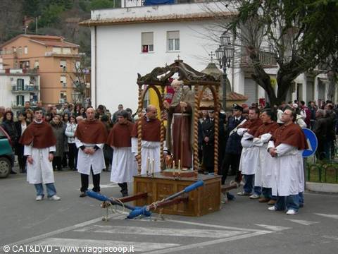 Brothers in white robes and brown capes carry a saint statue in procession