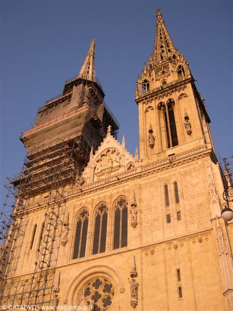 Zagreb Cathedral, neo-Gothic stone spires, one under scaffolding in golden light