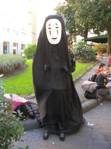 Cosplayer dressed as No-Face at Lucca Comics in a garden with students