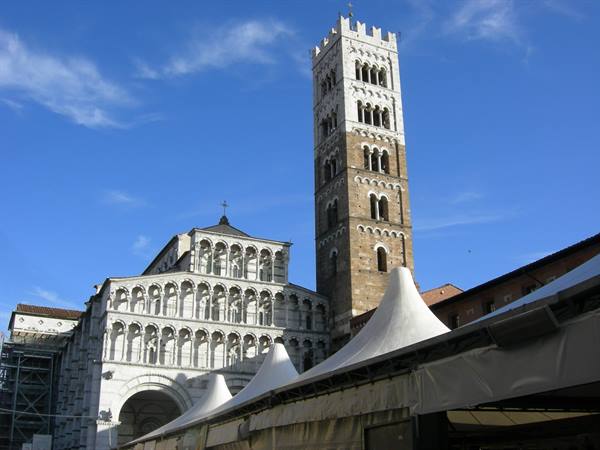St Martin's Cathedral in Lucca, marble facade and bell tower under blue sky