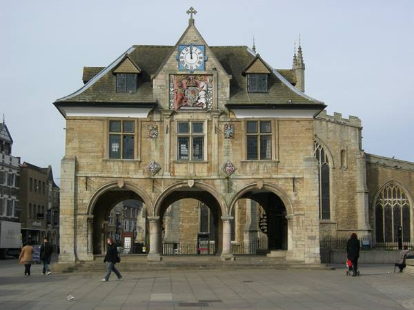 Peterborough Guildhall, stone building with arches and clock, people walking on the square
