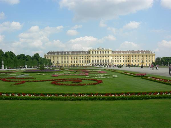 Flowerbeds in front of Schönbrunn's yellow facade, Vienna, cloudy sky