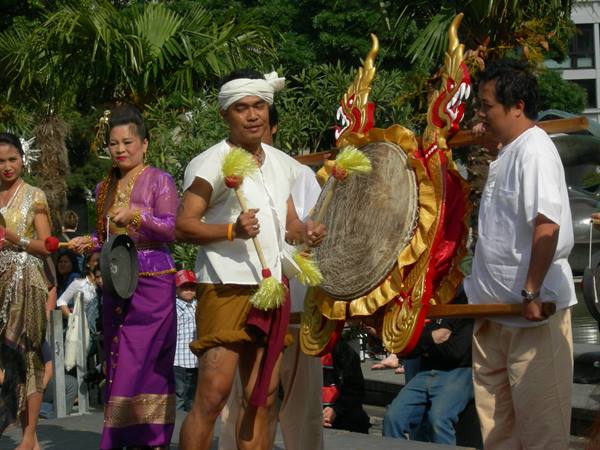Musicians in traditional costumes playing drum and gong in a parade