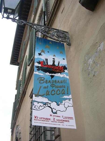 Lucca Comics banner hanging on a facade with wrought-iron lantern