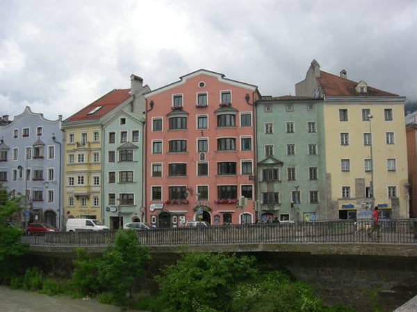 Colorful houses along the Inn river in Innsbruck under cloudy sky