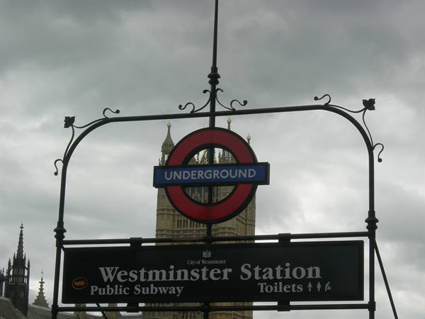Westminster Station Underground sign against a cloudy London sky
