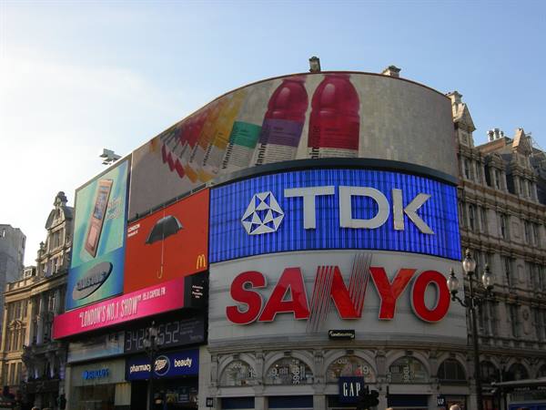 Piccadilly Circus, London: glowing TDK and Sanyo billboards on curved buildings