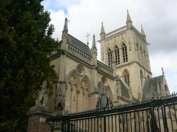 Gothic stone chapel with spires beside ornate wrought-iron gates, Cambridge