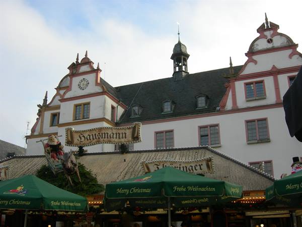 Christmas market under green umbrellas in front of the Hausmann building