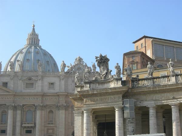 St Peter's dome and marble statues of the colonnade, daylight in Rome