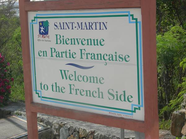 Saint-Martin tourist sign: Welcome to the French Side, surrounded by greenery