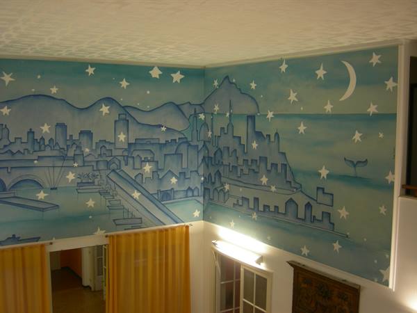 Blue mural with stars, moon and city skyline painted on indoor walls