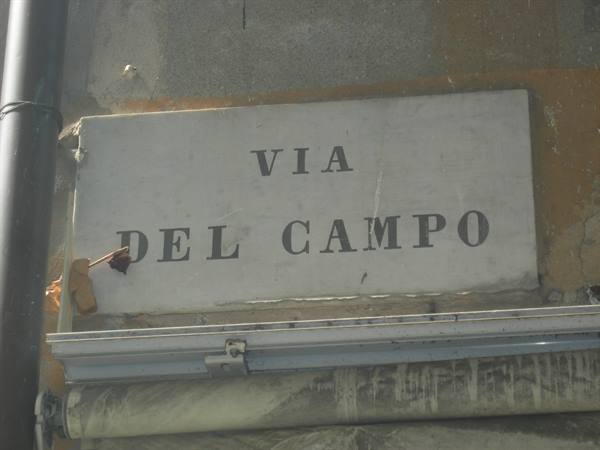 Marble street sign reading Via del Campo on a weathered wall