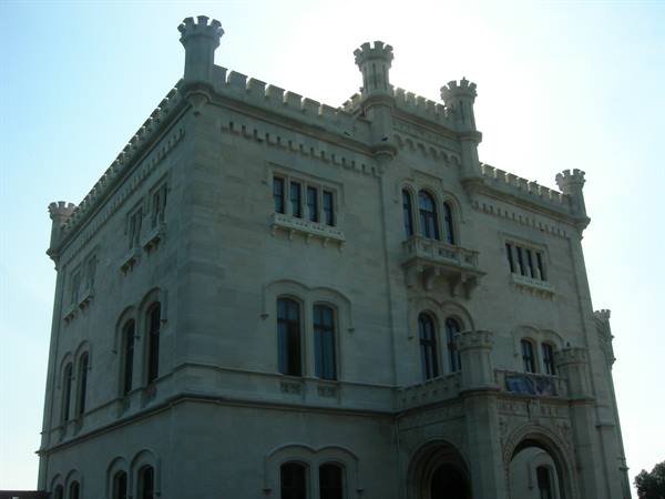 Miramare Castle: white neo-Gothic facade with crenellated towers in morning light