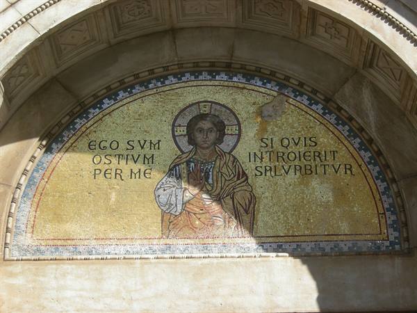 Byzantine mosaic of Christ in a stone lunette, diagonal sunlight