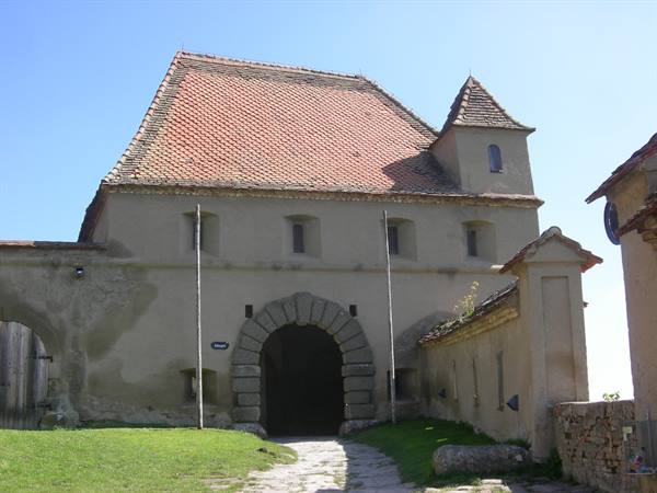 Medieval stone citadel with arched gateway and tiled roof, daylight