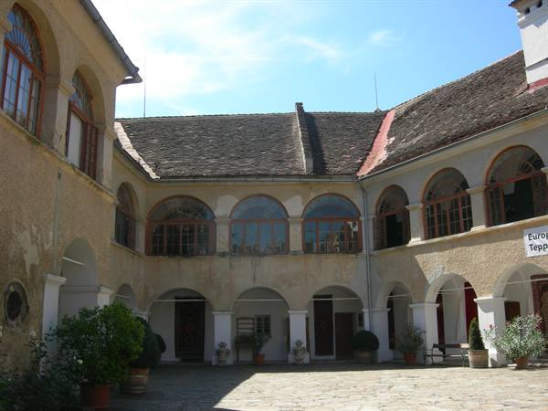 Sunlit courtyard with arched arcades of a historic building at midday