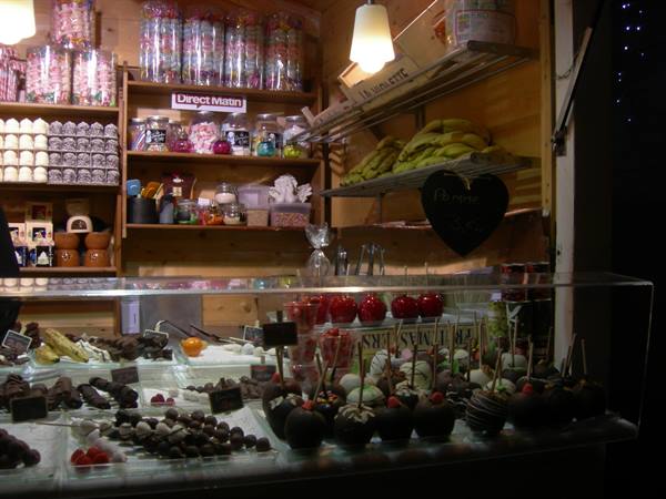 Candy stall at a Christmas market, chocolate-covered apples under glass