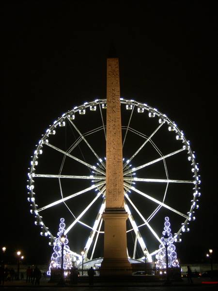 Luxor Obelisk at Place de la Concorde before the illuminated Ferris wheel at night