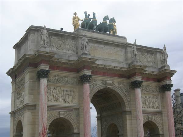 Arc de Triomphe du Carrousel in Paris, red marble columns and bronze quadriga under grey sky