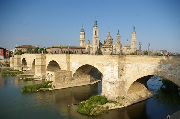 Stone bridge over the Ebro river with the Pilar basilica in Zaragoza