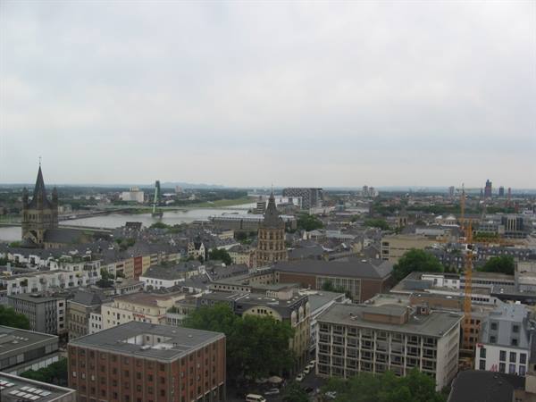 Above Cologne rooftops, Groß St. Martin church and the Rhine under grey sky