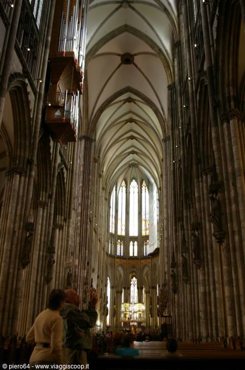 Gothic nave of Cologne Cathedral, stone vaults, tourists taking photos