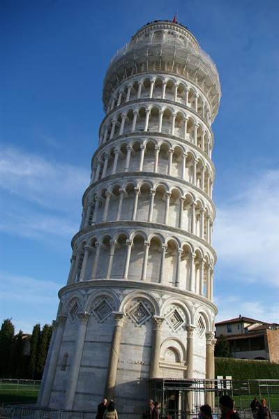 The Leaning Tower of Pisa in white marble, tourists below, blue sky