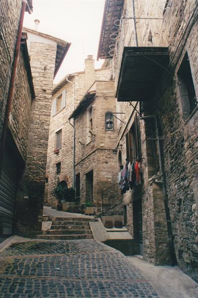Stone alley with steps and laundry hanging between medieval houses in Gubbio