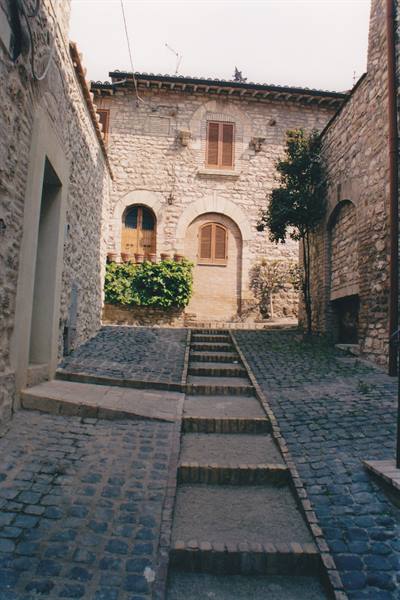 Stone steps between medieval houses in Assisi, soft light on cobblestones