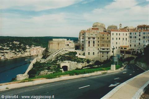 Bonifacio old town on limestone cliff above harbor, road in foreground