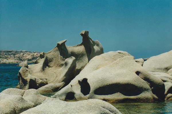 Wind-carved granite boulders rise above the turquoise water