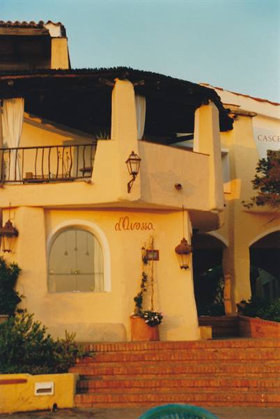 Yellow facade of d'Arossa bar with brick steps and lanterns