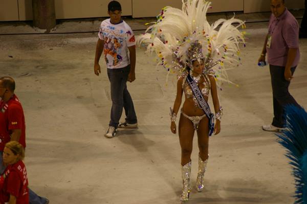 Dancer in silver costume with white feathers walks at the sambodrome