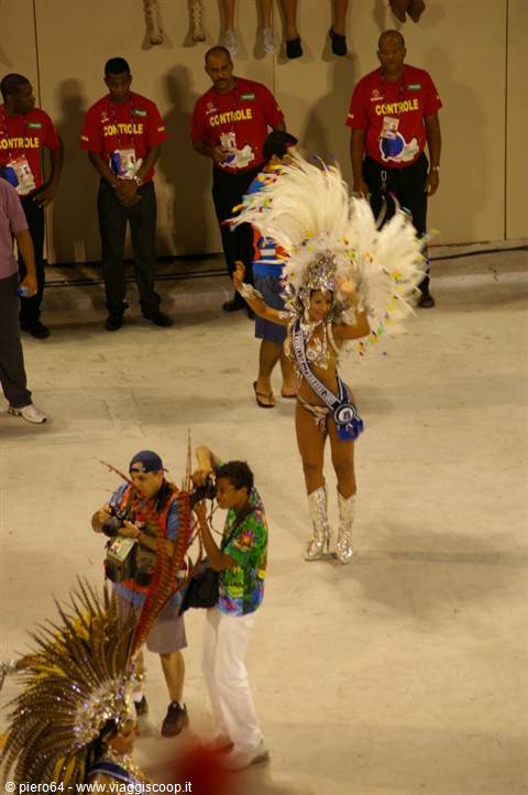 Dancer in white feather headdress poses for photographers at the Sambadrome