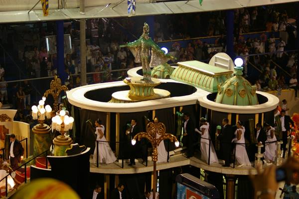 Carnival float at Rio's Sambódromo, dancers in white descend under bright lights