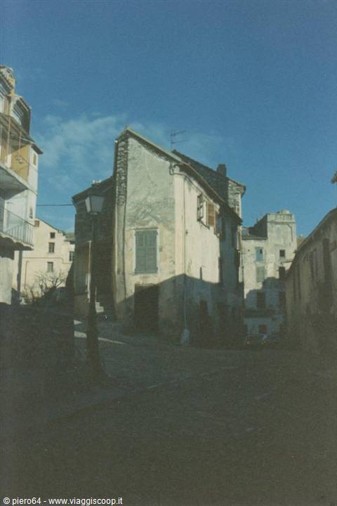 Old stone houses along a village street, blue sky